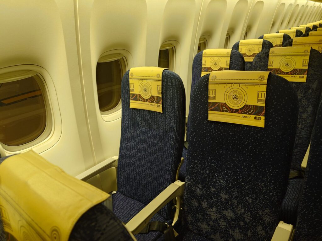 C-3PO ANA JET(JA743A)機内の特別仕様ヘッドレストカバー。ドロイドの意匠を凝らした黄金色のデザイン